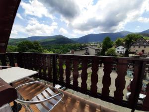 a balcony with a table and chairs and mountains at Usługi hotelarskie Karpacz in Karpacz