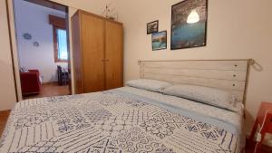 サン・フォカにあるCasa vacanza Poesiaのベッドルーム1室(ベッド1台付)、木製キャビネットが備わります。