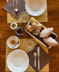 a table with plates and utensils and pastries on it at Hotel-Motel70 in San Nazzaro +57 photos