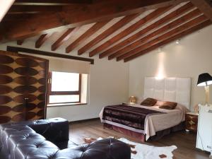 een slaapkamer met een bed en een bank bij LA POSADA in Silió
