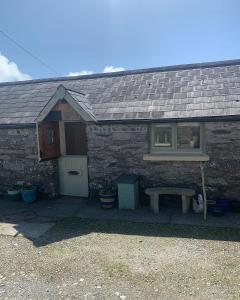 ein Haus mit einem Fenster und einer Bank davor in der Unterkunft Ancaire Studio in Schull