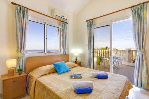 a bedroom with a large bed with two towels on it at Villa Azalea by Villa Plus in Peyia +19 photos