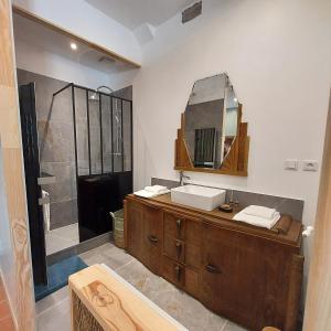 La salle de bains est pourvue d'un lavabo et d'un miroir. dans l'établissement Les Chambres du Château du Rozel, à Le Rozel