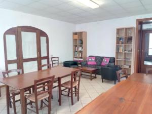 a dining room with tables and chairs and a couch at Ex Latteria di Platischis in Taipana