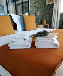 un lit avec deux serviettes posées dessus dans l'établissement lodge-bélvédere sur les hauteurs de vichy, à Vichy 102 autres photos