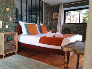 Un dormitorio con una cama con almohadas de colores y una ventana en lodge-bélvédere sur les hauteurs de vichy en Vichy