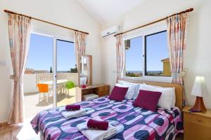 a bedroom with a bed and large windows at Villa Gardenia by Villa Plus in Peyia +42 photos