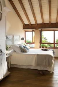 a bedroom with a large bed in a room with windows at LA POSADA in Silió