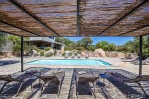 an outdoor patio with chairs and a swimming pool at Villa 18 in Porto-Vecchio