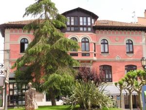 
a large building with a tree in front of it at Hotel Casona del Sella in Arriondas
