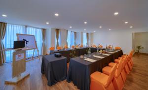 a meeting room with a long table and orange chairs at Aabas Pokhara by Barahi Hospitality in Pokhara