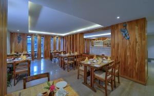 a restaurant with wooden walls and tables and chairs at Aabas Pokhara by Barahi Hospitality in Pokhara