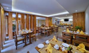 a restaurant with wooden tables and wooden chairs at Aabas Pokhara by Barahi Hospitality in Pokhara