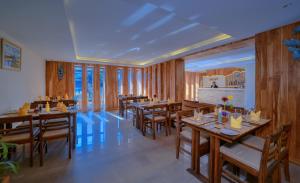 a dining room with wooden tables and chairs at Aabas Pokhara by Barahi Hospitality in Pokhara