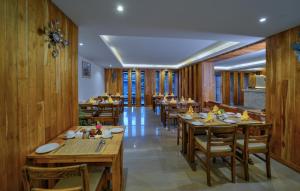 a restaurant with wooden walls and tables and chairs at Aabas Pokhara by Barahi Hospitality in Pokhara