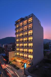 a tall building with lights on in a city at Aabas Pokhara by Barahi Hospitality in Pokhara