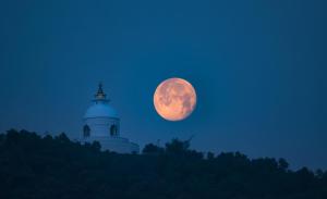 a full moon rises over a lighthouse and lighthouse at Aabas Pokhara by Barahi Hospitality in Pokhara