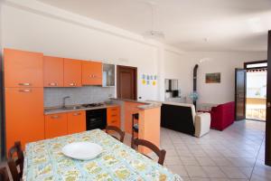 een keuken en een woonkamer met een tafel en een tafel en een eetkamer bij La Caletta casa per vacanze in La Caletta