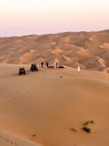 a group of people standing in the sand in the desert at Liwa Nights ليالي ليوا in Liwa
