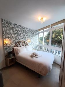 Un dormitorio con una cama con dos zapatos. en Joan Miró Luxury Torremolinos, en Torremolinos