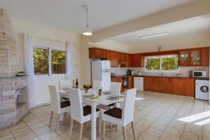 a kitchen and dining room with a table and chairs at Villa Pandora by Villa Plus in Peyia