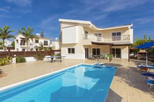a villa with a swimming pool in front of a house at Villa Pandora by Villa Plus in Peyia