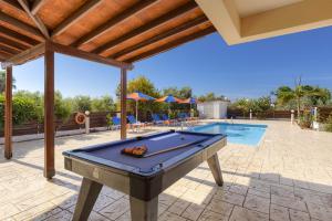 a pool table in a yard with a swimming pool at Villa Pandora by Villa Plus in Peyia