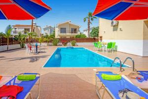 a swimming pool with two umbrellas and a pool at Villa Semeli by Villa Plus in Peyia