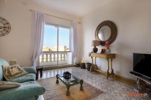 sala de estar con sofá y espejo en Eclectic Apartment with Incredible Harbour views, en Senglea