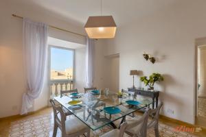 a dining room with a table and chairs and a window at Eclectic Apartment with Incredible Harbour views in Senglea