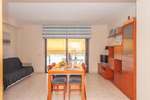 Il comprend une cuisine et un salon avec une table et des chaises. dans l'établissement APPARTEMENT DU SOLEIL, à Lloret de Mar