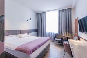 ein Hotelzimmer mit einem Bett und einem TV in der Unterkunft Scandic Gdańsk in Danzig