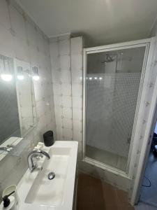 uma casa de banho branca com um lavatório e um chuveiro em Bel appartement pour vos séjours sur la côte em Nice