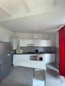 Bel appartement pour vos séjours sur la côte في نيس: مطبخ صغير مع دواليب بيضاء وثلاجة