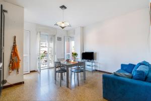 ein Wohnzimmer mit einem Tisch und einem blauen Sofa in der Unterkunft Iris Apartment Lago Maggiore in Angera
