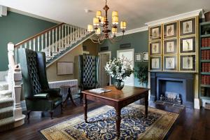 a living room with a table and a fireplace at The Riverside, WorldHotels Distinctive in Salisbury