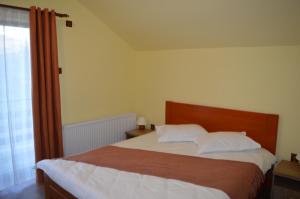 BoholtにあるPensiunea La Taica Iacobの大きなベッドと窓のある寝室