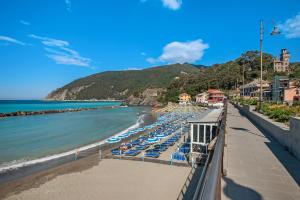 a beach with a bunch of chairs and the ocean at Miriam e Carlo in Moneglia