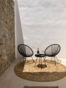 two chairs and a table with a bottle of wine at Sun House Paros in Kampos Paros
