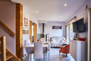 sala de estar con mesa de comedor y TV en Gîte les Galets chantants, en Saint-Hilaire-du-Rosier