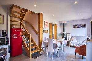 Habitación con nevera roja, mesa y sillas. en Gîte les Galets chantants, en Saint-Hilaire-du-Rosier