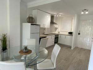 cocina con mesa de cristal y sillas blancas en Apartamentos Stil Mar Anna - Stil Mar Anna L'Escala 4, en L'Escala 37 fotos más
