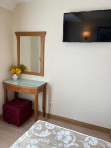 イスタンブールにあるヤウス ホテルのテーブル、鏡、スツール付きの部屋