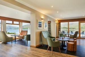 a hotel lobby with chairs and tables and windows at Clan Macduff Hotel in Fort William