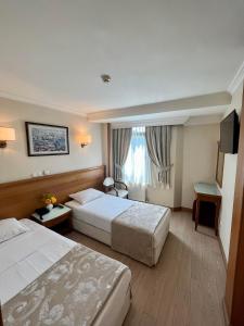 Un pat sau paturi într-o cameră la Yavuz Hotel