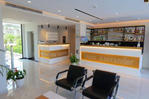 een hotellobby met 2 stoelen en een balie voor hoteladviseurs bij Hotel Alexander in Ksamil