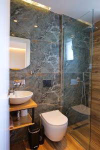 a bathroom with a toilet and a sink and a shower at Hotel Alexander in Ksamil