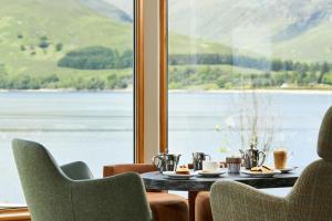 a table and chairs with a view of a lake at Clan Macduff Hotel in Fort William