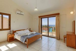 Schlafzimmer mit einem Bett und Meerblick in der Unterkunft Villa Harmony by Villa Plus in Peyia