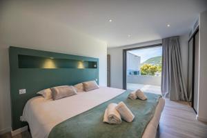 a bedroom with a large bed with two pillows on it at Villa 19 in Zonza +16 photos